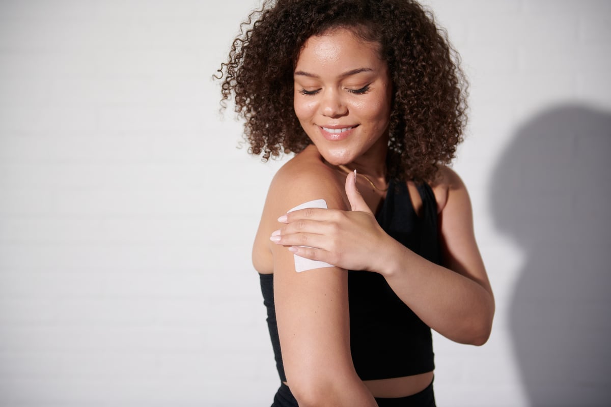 Model putting on patch on her arm