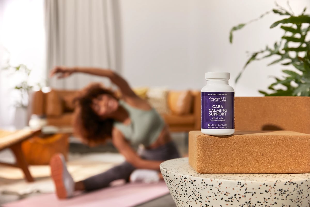 Model stretching in background with BrainMD product in focus