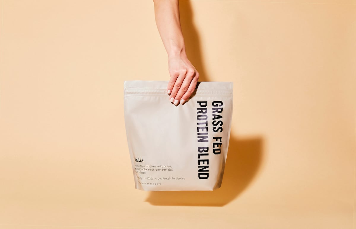 Hand holding bag of grass fed protein blend 