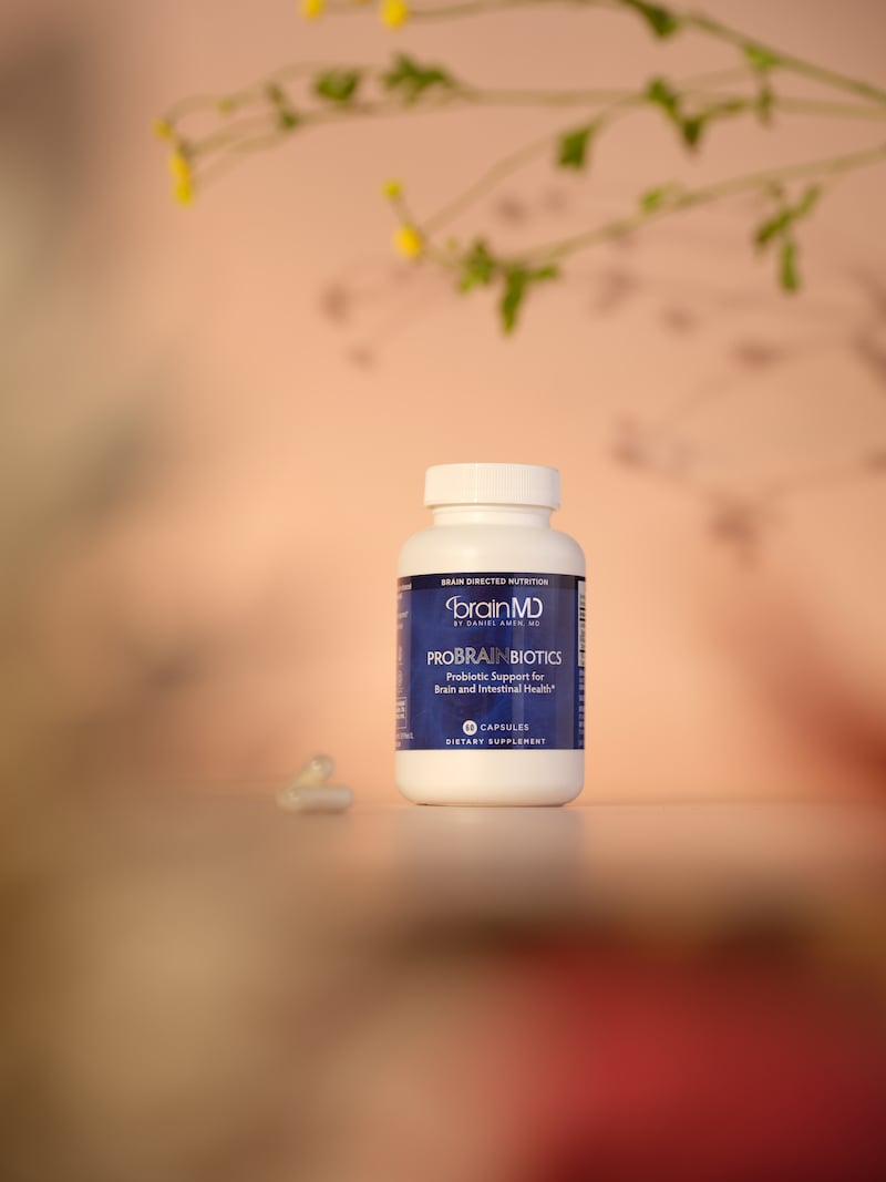 BrainMD proBRAINbiotics bottle with flowers in the foreground and background